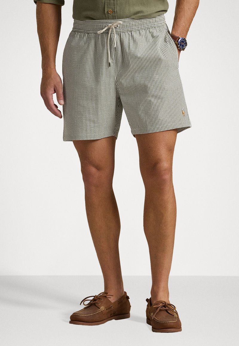 Shorts de baie cu dungi în verde deschis și alb, material ușor, talie elastică cu șnur, buzunare laterale, detaliu mic cu logo.