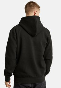 Felpa nera con cappuccio alto, cappuccio regolabile con cordini e polsini a coste. Realizzata in tessuto morbido, con una vestibilità comoda e texture liscia.