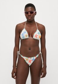 Zestaw bikini z trójkątnym topem i wiązanym dołem, ozdobiony haftowanymi wzorami morskimi w niebieskim, pomarańczowym i zielonym na jasnym materiale.