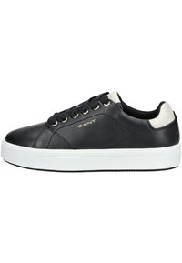 Czarne skórzane sneakersy z białą gumową podeszwą, z sześcioma dziurkami, złotym logo i kontrastującym, teksturowanym uchwytem na pięcie.