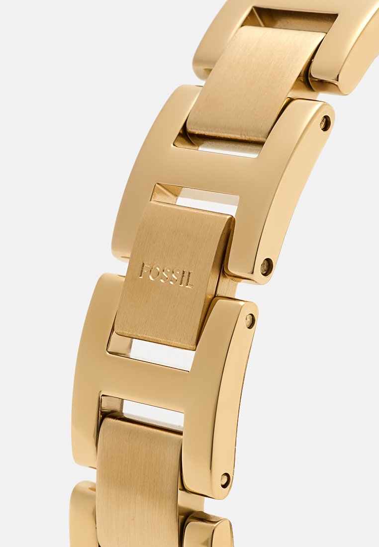 Goudkleurige metalen horlogeband met rechthoekige schakels, voorzien van een geborstelde afwerking en geïntegreerd Fossil-logo op een schakel. Glad, gepolijst rand.