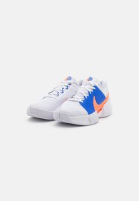 Weiße Sportschuhe mit blauen und orangefarbenen Akzenten, strukturiertes Mesh-Obermaterial, gepolsterter Kragen und gummierte Außensohle mit einem gemusterten Profil.