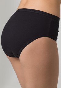 Black ribbed underwear with a seamless design, featuring a soft, stretchy waistband embossed with the brand name. Classic hipster cut.