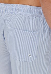 Jasnoniebieskie szorty w białe paski z elastycznym paskiem w talii, z jedną tylną kieszenią i detalem w postaci guzika.