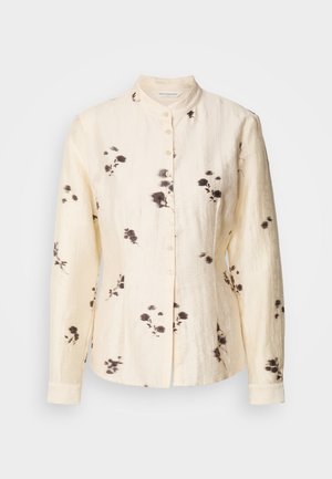 Kremowa bluzka z długim rękawem z kołnierzykiem mandaryńskim, z przodem na guziki, delikatnym czarnym kwiatowym wzorem i teksturowaną tkaniną.