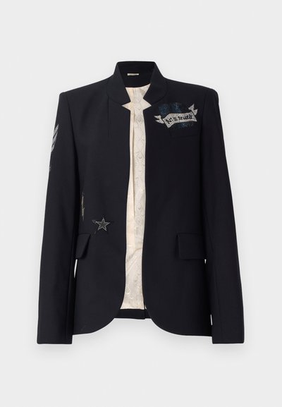 Blazer noir à col haut, avec des patchs en étoiles argentées et texturées, et une doublure crème avec un motif délicat.