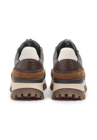 Sneaker con una combinazione di tessuto grigio e suede marrone, dotate di una spessa suola in gomma e dettagli testurizzati sul tallone e sul pannello posteriore.