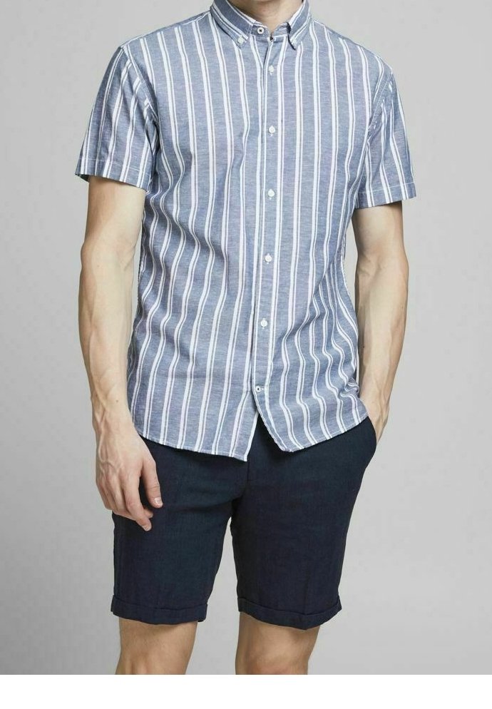 Blå kortärmad skjorta med knappar och vertikala vita och rosa ränder; matchad med mörkblå uppvikta shorts; i bomullsmaterial.
