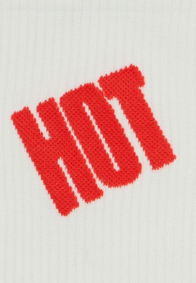 Tecido branco com texto em malha em destaque, a dizer "HOT" em vermelho brilhante. O fundo tem um padrão texturizado em nervuras.