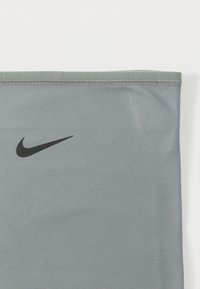 Γκρι αθλητικό ύφασμα με ομαλή υφή, που διαθέτει μαύρο λογότυπο Nike και ραμμένα άκρα. Σχεδιασμένο σε μια αδιάλειπτη, σωληνοειδή μορφή.