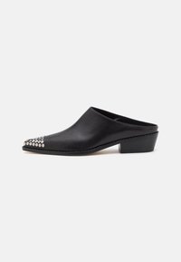 Mules in pelle nera con punta arrotondata e tacco basso a blocco. Borchiette decorative in argento nell'area della punta per un tocco di stile. Texture liscia su tutta la superficie.
