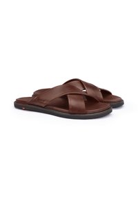 Sandali in pelle marrone con un design a bande incrociate, una superficie liscia e suola in gomma nera. Presentano un branding minimal sul lato.