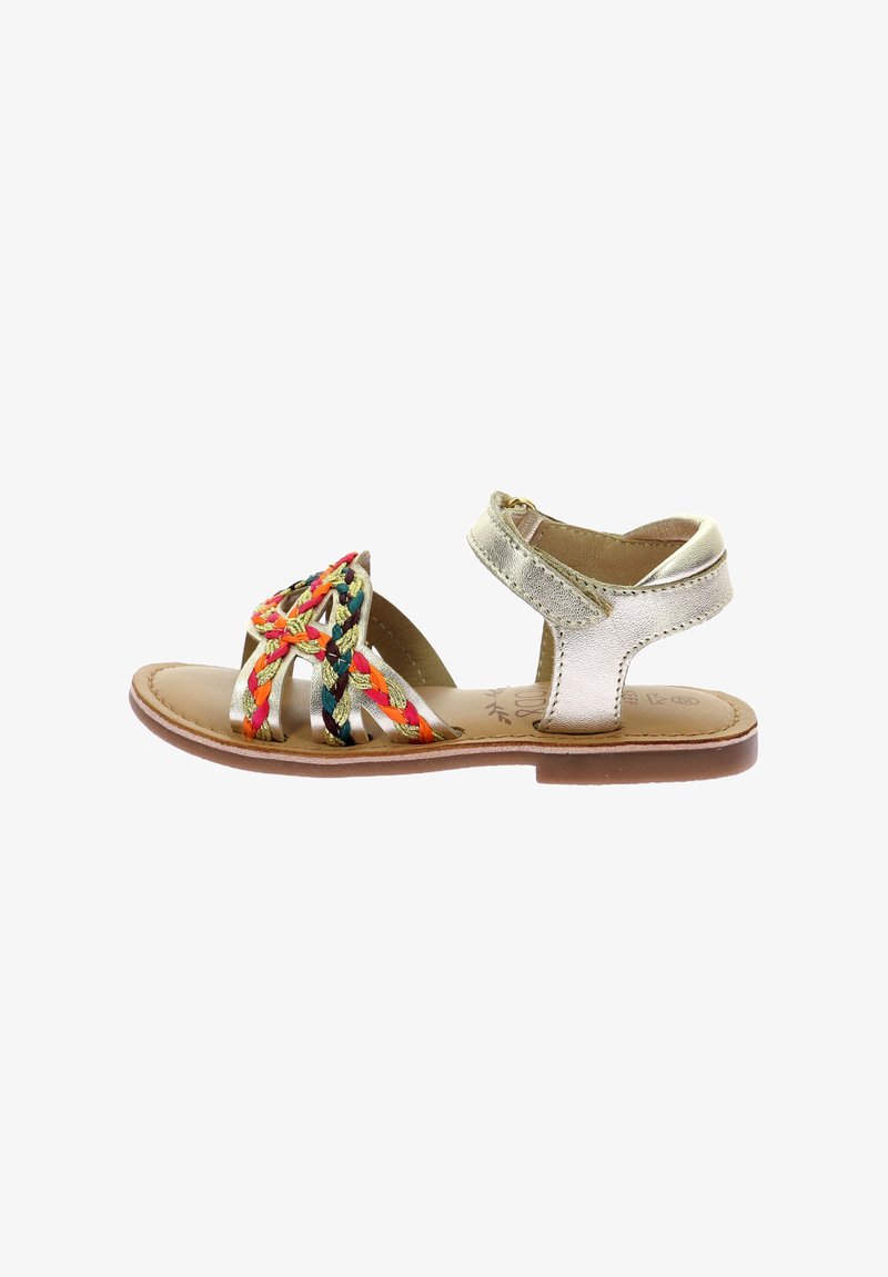 Sandale en cuir doré avec une bride tressée multicolore aux accents rouge, jaune et vert. Semelle plate avec fermeture à bride de cheville.