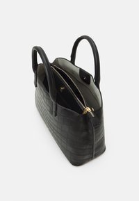 Svart krokodilpräglad läderhandväska med två handtag, guldfärgad dragkedja och en rymlig insida med flera fack.