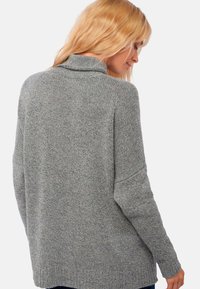 Grau gestrickter Pullover mit hohem Kragen, lockerer Passform, weiten Ärmeln und geripptem Saum. Verfügt über ein strukturiertes, weiches Material für zusätzlichen Komfort.