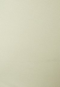 Tecido ribado de um bege claro com uma textura suave. O material apresenta finas linhas verticais, criando um padrão sutil em toda a sua extensão.