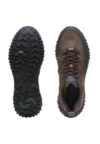 Braune Wanderschuhe mit strukturiertem Leder-Obermaterial, Gummisohle mit tiefen Stollen für besseren Halt und grünem Akzent an der Ferse.