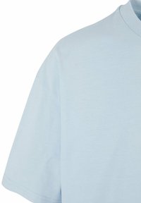 Camiseta de algodón azul claro con cuello redondo, mangas cortas y una textura suave. Presenta costuras limpias y un diseño minimalista.