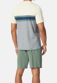 T-shirt pour homme en crème et gris, avec des rayures horizontales vertes et bleues. Assorti à un short vert. Mélange de coton, coupe décontractée.