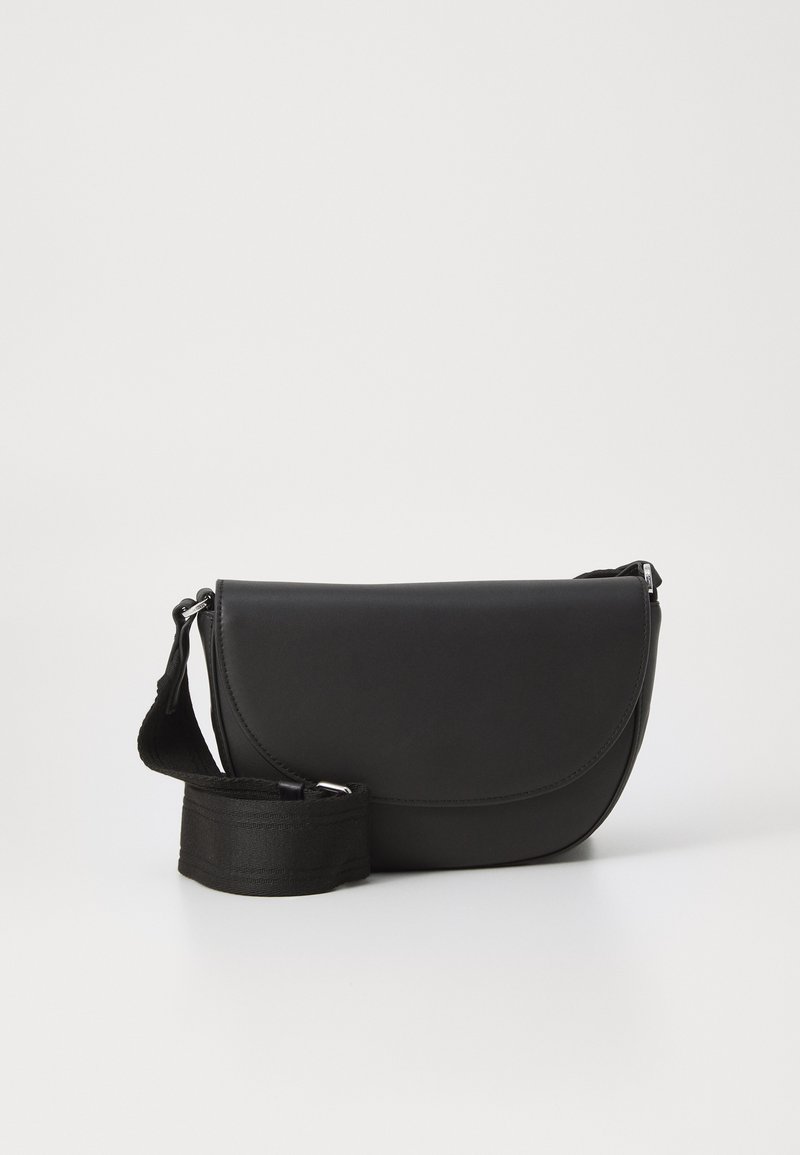 Borsa a tracolla in pelle nera con patta curva, dalla texture liscia e con tracolla in tessuto rimovibile. Design semplice senza hardware visibile.