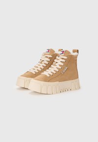 Sneaker high-top in suede color tan con suola bianca spessa, dotate di lacci crema, una patch con logo sulla lingua e fodera in pelliccia.