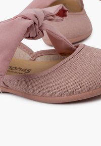 Pantofi din țesătură împletită roz, cu un accent din panglică legată. Designul are vârful rotund și o suprafață texturată moale.
