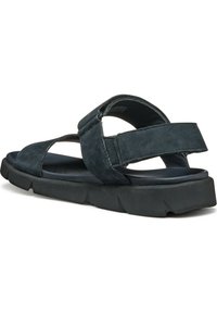Sandali in suede di colore blu scuro con fasce larghe, design aperto sulla punta e suola nera imbottita. Presentano una chiusura regolabile per una vestibilità ottimale.