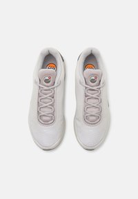 Scarpe sportive grigio chiaro con tomaia in rete, chiusura con lacci, imbottitura Air Max visibile e dettagli in gomma nella suola.