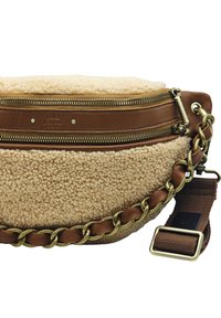 Sac en tissu sherpa beige avec des accents en cuir marron et un détail en chaîne dorée. Il dispose de deux compartiments zippés et d'une bandoulière texturée réglable.