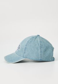 Világoskék denim baseball sapka. Ívelt karima, hímzett logó az elején, és hatpaneles kialakítás varrási részletekkel.