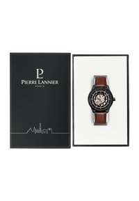 Reloj negro con esfera esqueleto, correa de cuero marrón y acentos plateados, presentado en una caja negra con interior blanco y logo.