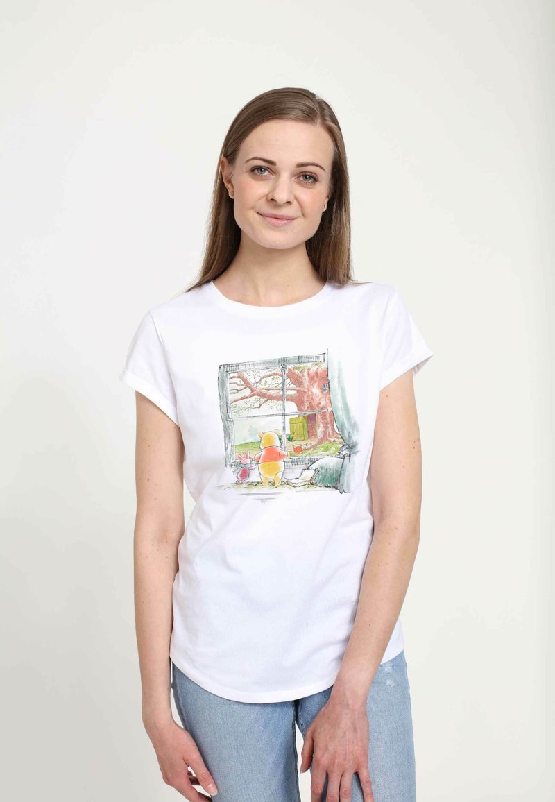 Weißes Baumwoll-T-Shirt mit einem bunten Druck von Winnie Puuh und Ferkel, die aus einem Fenster schauen, mit einem Baum und Landschaft im Hintergrund.