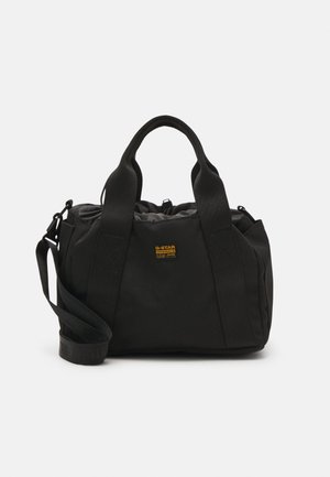 Sac polochon noir G-Star Originals avec doubles poignées, bandoulière réglable et petit patch logo jaune au centre avant.