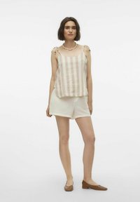 Lichte, beige gestreepte tanktop met schouderbandjes, gecombineerd met crèmekleurige textuurschoenen. Bruine platte schoenen maken de outfit compleet.