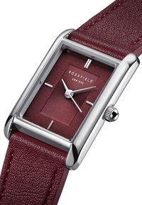 Cassa orologio in acciaio inossidabile argento rettangolare con quadrante burgundy testurizzato, tre indicatori delle ore argentati e un cinturino in pelle burgundy.
