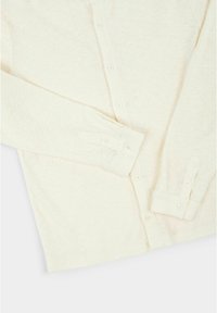 Lichtbeige cardigan gemaakt van textuurstof. Heeft een knoopsluiting aan de voorkant en lange mouwen met ronde manchetten.