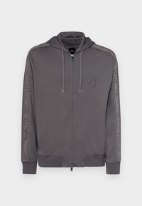 Šedá mikina na zips vyrobená z mäkkého materiálu, so sťahovacou kapucňou, bočnými vreckami a embosovaným logom na rukávoch.