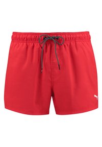 Rote Badeshorts aus leichtem Material. Verfügt über einen elastischen Bund mit Kordelzug und ein weißes Logo auf der unteren rechten Seite.