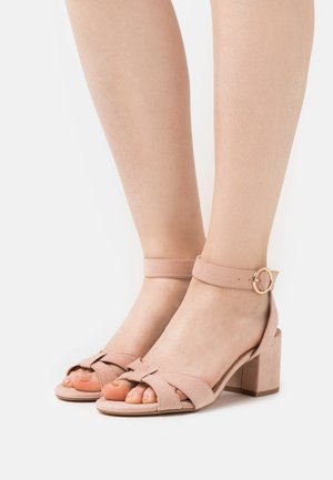 Roze suède sandalen met blokhak en enkelbandje, met gekruiste ontwerpen en een ronde gespdetail.
