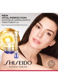 Femme à la peau claire posant à côté des produits de soin Shiseido Vital Perfection et d'un tourbillon de liquide doré, promouvant un traitement anti-rides.