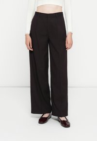 Breda svarta pinstripe-byxor med en mjuk textur, som har hög midja, skräddarsydd design och sidofickor. I kombination med blanka skor.