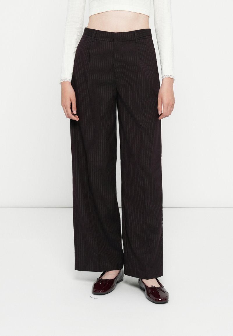 Breda svarta pinstripe-byxor med en mjuk textur, som har hög midja, skräddarsydd design och sidofickor. I kombination med blanka skor.