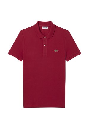 Camisa polo roja hecha de algodón, con cuello tipo polo y dos botones, mangas cortas y un pequeño logo de cocodrilo verde en el pecho.