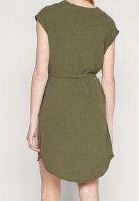 Dámské šaty olivově zelené barvy s páskem, krátkými rukávy, lehkého materiálu, kulatým lemem a bočními rozparky; mají volný střih a hladkou texturu.