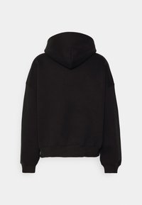 Sudadera negra con una capucha grande, diseño holgado, puños y dobladillo acanalados, hecha de una tela suave y texturizada. Sin patrones ni elementos metálicos visibles.