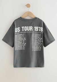 Szara bawełniana koszulka z krótkim rękawem, z białym nadrukiem na plecach przedstawiającym daty koncertów "US TOUR 1978".