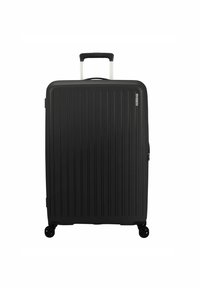 Valigia rigida nera con scanalature verticali, manico telescopico argentato e quattro ruote nere per la mobilità. Chiusura a zip sul lato.