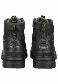 Botas impermeables negras con un diseño resistente, tela texturizada, refuerzo en el talón y una tira de agarre a rayas. Presentan una suela con patrón para mayor tracción.