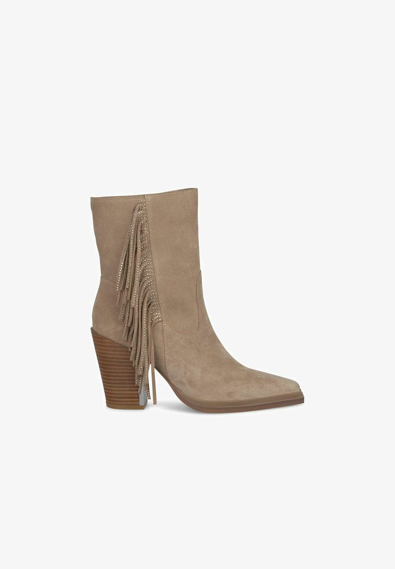 Botín de ante beige hasta el tobillo con punta afilada, flecos detallados en el costado y un tacón de madera apilada. Textura suave y costuras mínimas.