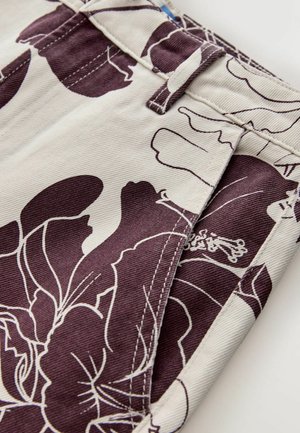 Světlá látka s výrazným fialovým květinovým vzorem, s přiléhavým střihem, kapsami a pasem s poutky na pásek.